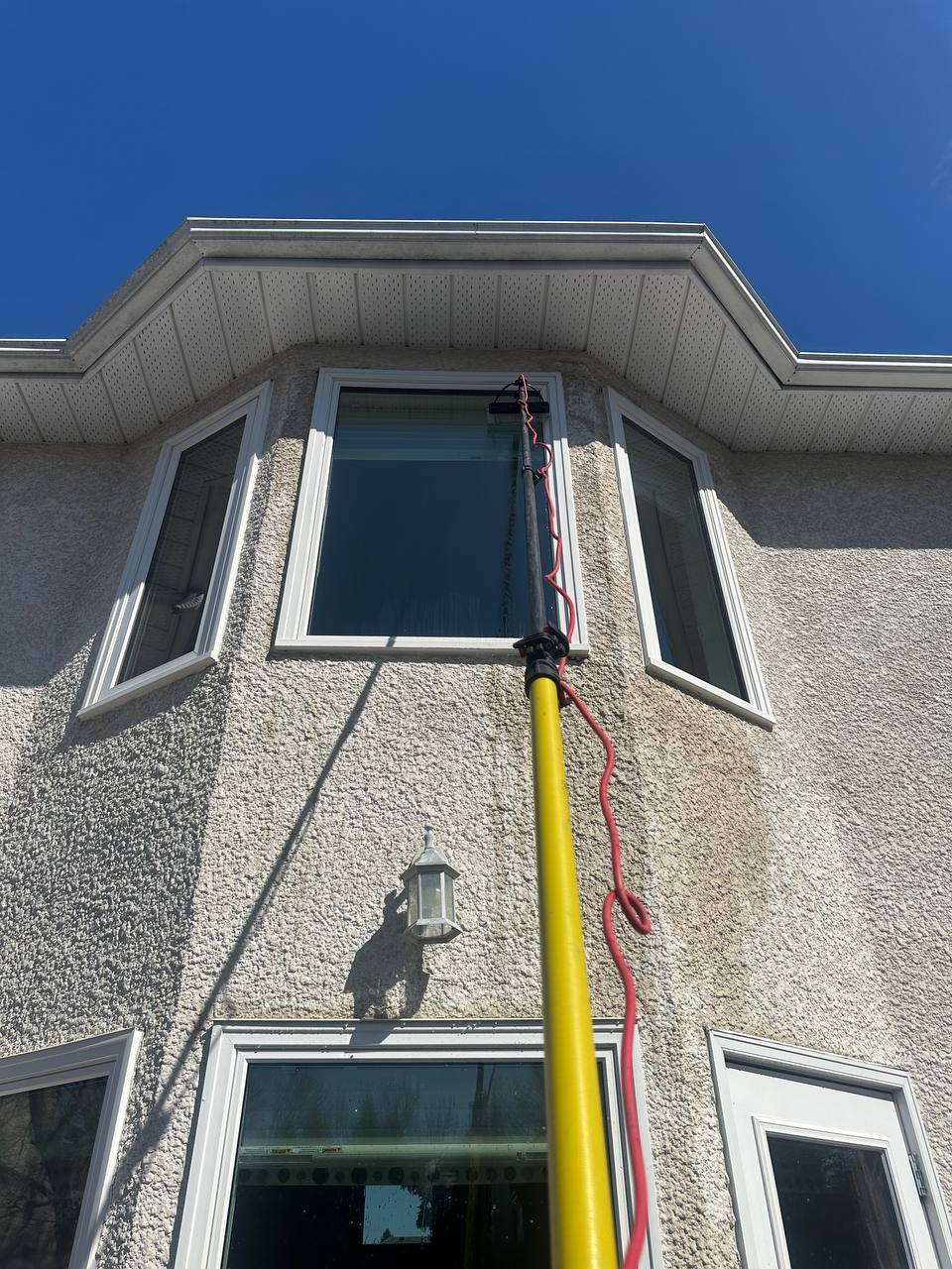 Water-fed pole reaching an upstairs window of a Winnipeg home
